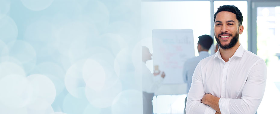 Smiling African American woman sitting in front of laptop, holding a pencil.
